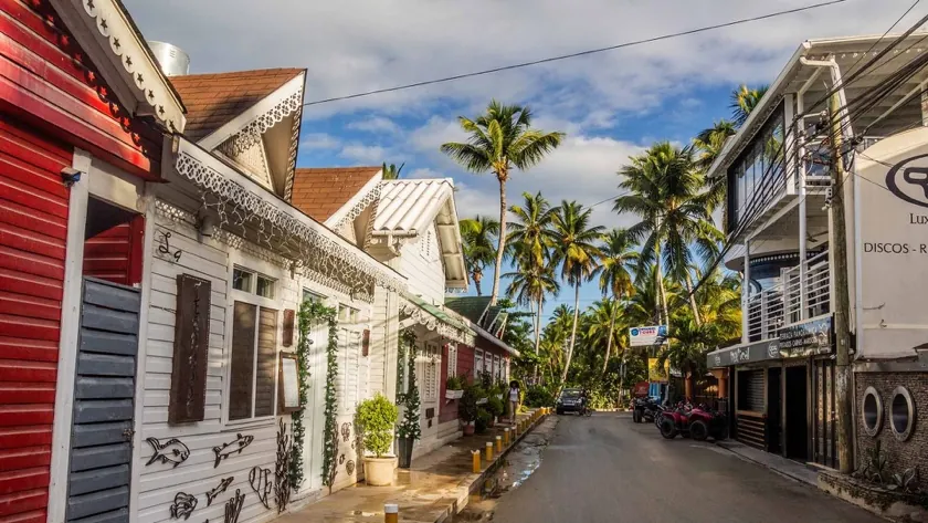 Coastal street of Las Terrenas with shops and palm trees