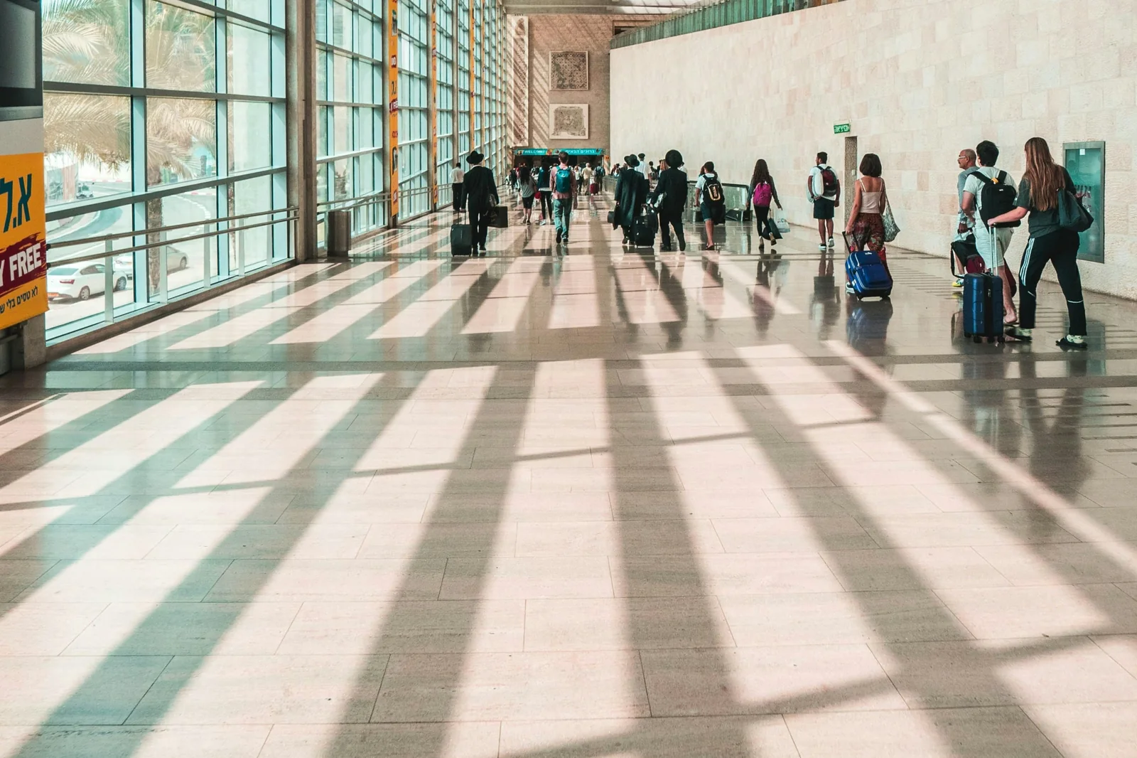 Pasajeros caminando con sus maletas por la terminal de llegadas